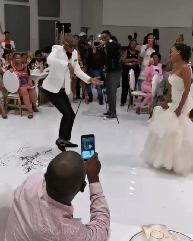 Black bride and groom dancing on a white floor at their wedding reception